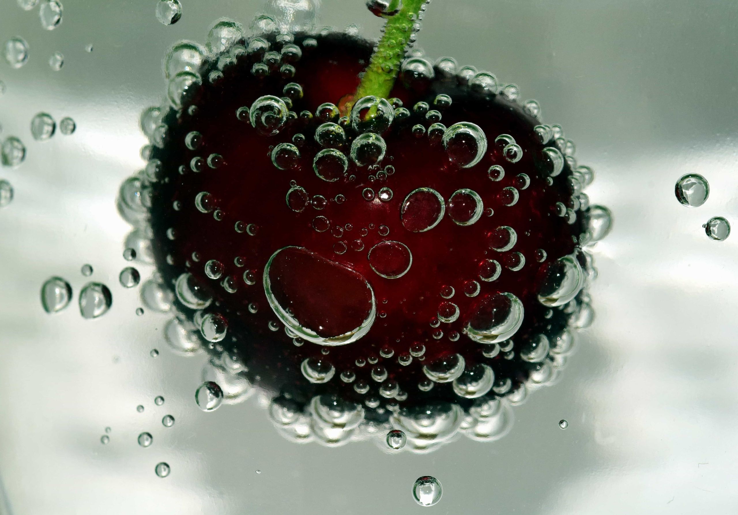 Macro detail of a cherry surrounded by effervescent bubbles